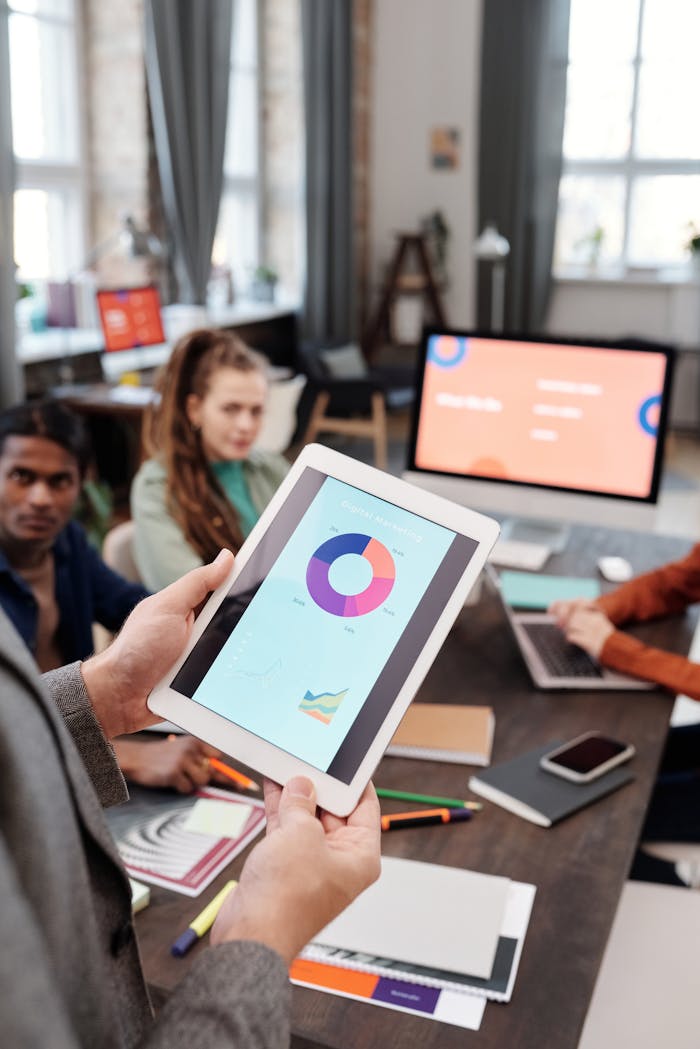 Colleagues reviewing business data on a tablet in a modern office setting.